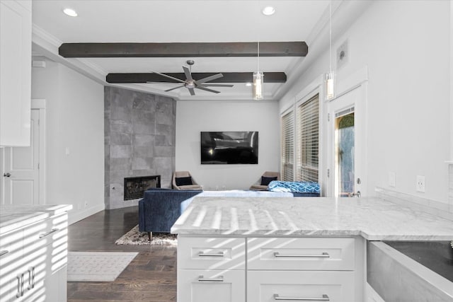 1503 Juliet St, Austin, TX 78704 - kitchen with dark wood-style flooring, a ceiling fan, white cabinets, beamed ceiling, and light stone countertops
