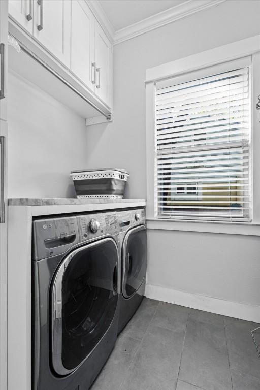 1503 Juliet St, Austin, TX 78704 - washroom with washer and dryer, crown molding, cabinet space, and tile patterned floors