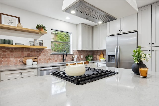 kitchen featuring decorative backsplash, light stone countertops, and appliances with stainless steel finishes