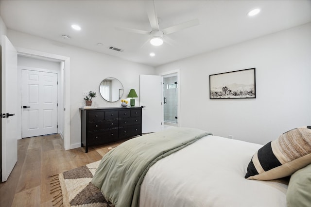 bedroom featuring ceiling fan, light hardwood / wood-style flooring, and ensuite bath