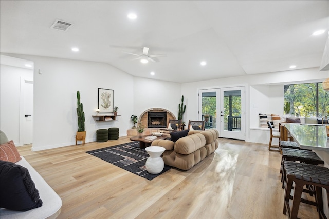 living room featuring french doors, vaulted ceiling, light hardwood / wood-style flooring, and ceiling fan