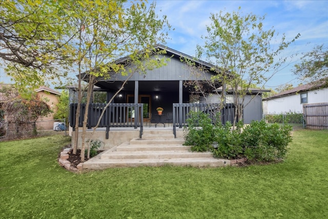 rear view of property featuring a lawn