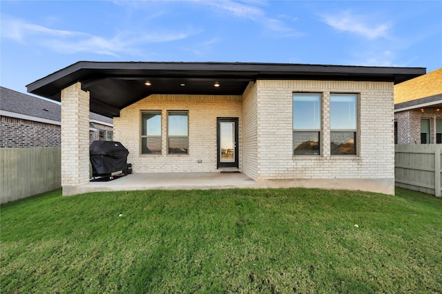 rear view of house with a yard and a patio