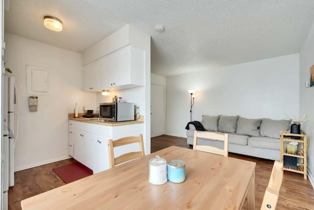 dining space featuring a textured ceiling and hardwood / wood-style flooring