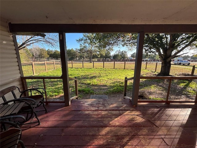 wooden terrace featuring a yard and a rural view