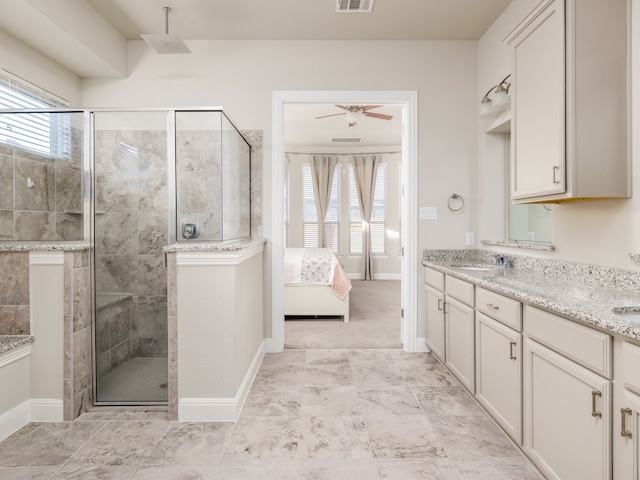 bathroom with vanity, ceiling fan, and a shower with door