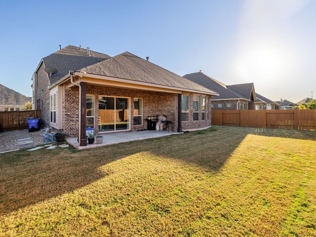 back of house featuring a lawn and a patio