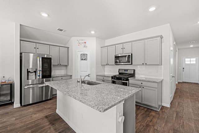 kitchen featuring gray cabinetry, stainless steel appliances, dark wood-type flooring, sink, and a center island with sink