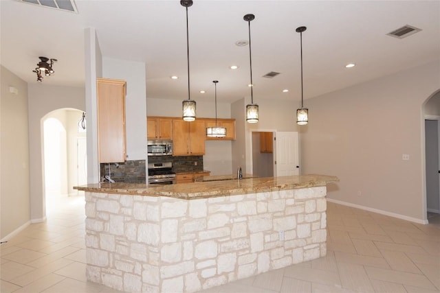 1709 Todd Ln, Cedar Park, TX 78613 - kitchen featuring arched walkways, appliances with stainless steel finishes, backsplash, light stone countertops, and recessed lighting
