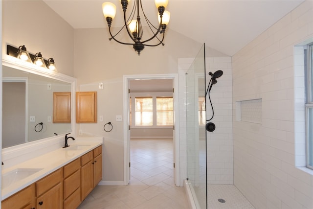 bathroom featuring vanity, vaulted ceiling, tiled shower, an inviting chandelier, and tile patterned flooring