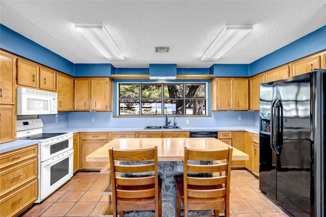 kitchen featuring a kitchen breakfast bar, light tile patterned floors, black appliances, and a textured ceiling