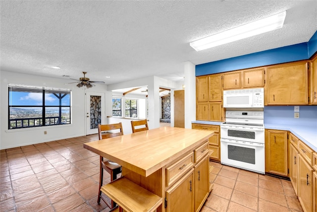 kitchen featuring a textured ceiling, ceiling fan, and white appliances