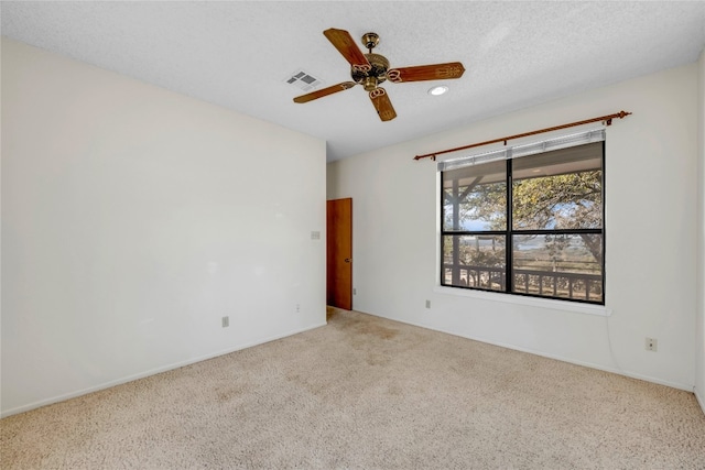 spare room with ceiling fan, carpet, and a textured ceiling