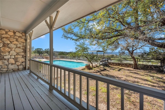 wooden terrace featuring a fenced in pool