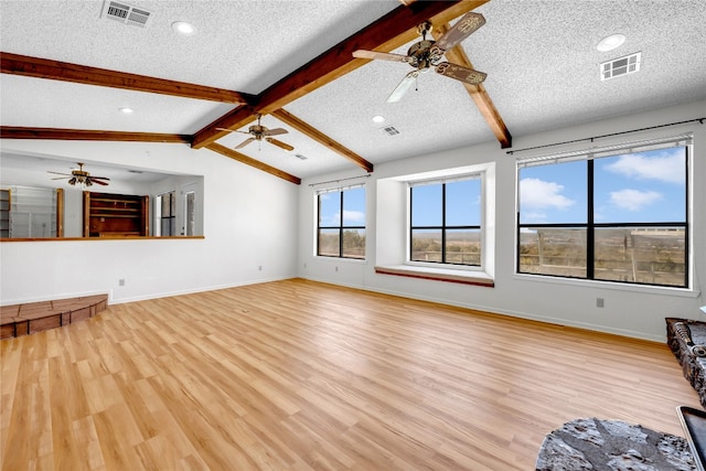 unfurnished living room with light wood-type flooring and a textured ceiling