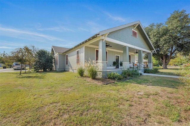 view of side of home with a lawn, ceiling fan, and a porch