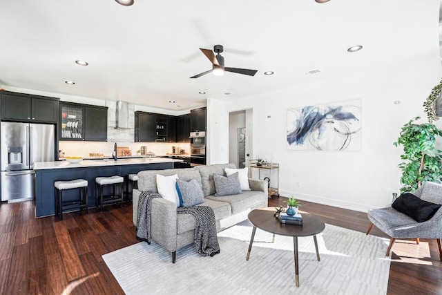 living room with ceiling fan, sink, and dark hardwood / wood-style flooring