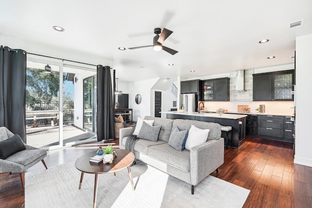 living room featuring ceiling fan, sink, and dark hardwood / wood-style floors