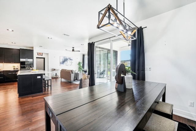 dining room featuring dark hardwood / wood-style floors, sink, and ceiling fan