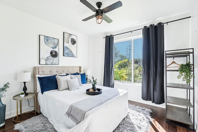 bedroom with dark hardwood / wood-style flooring and ceiling fan