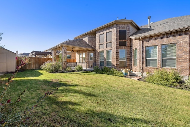 back of property with a lawn and a storage shed