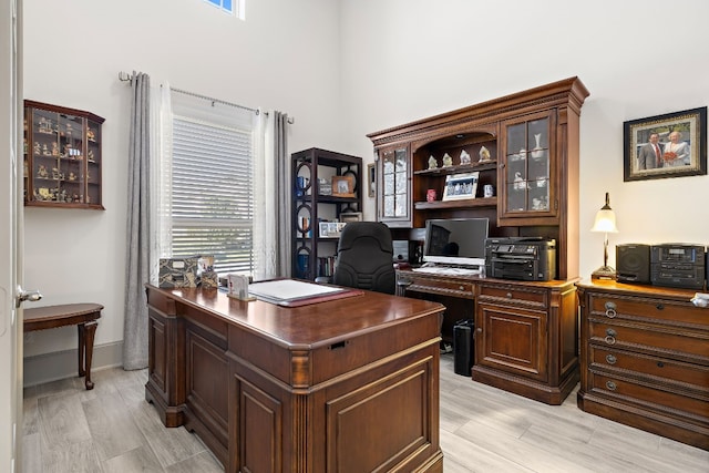 home office with light hardwood / wood-style flooring