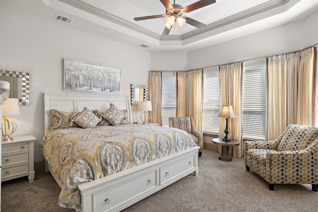 carpeted bedroom featuring ceiling fan, crown molding, and a tray ceiling