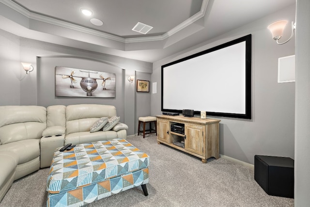 cinema room featuring a raised ceiling, light carpet, and ornamental molding