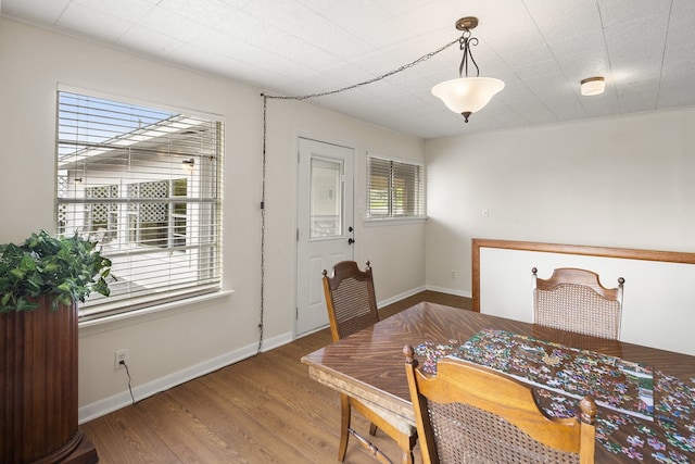 dining space featuring hardwood / wood-style floors and crown molding