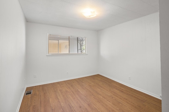 unfurnished room featuring hardwood / wood-style floors and a textured ceiling