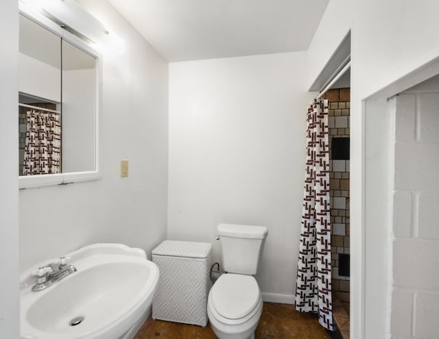 bathroom featuring a shower with curtain, sink, and toilet