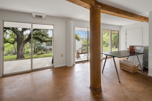 unfurnished dining area with beamed ceiling and concrete floors