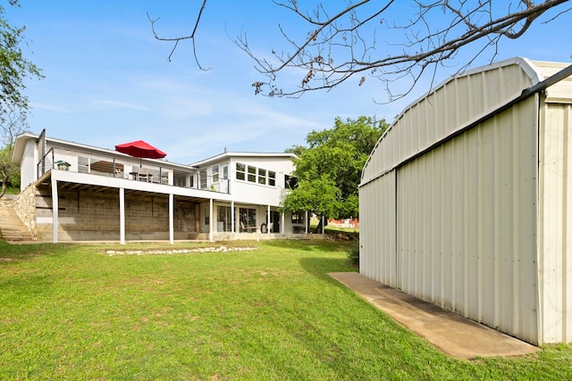 rear view of house with an outdoor structure and a yard