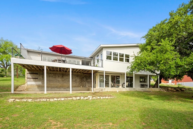 back of property featuring a lawn, a deck, and a patio