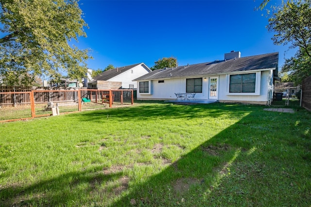 rear view of property with a lawn