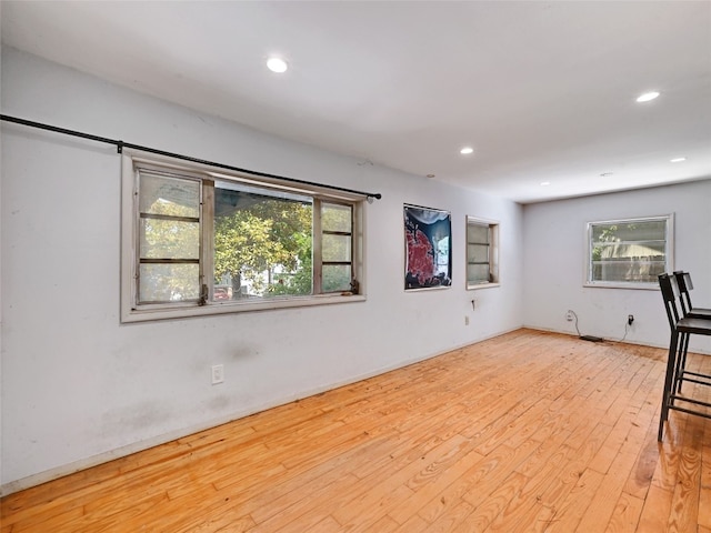 basement featuring light hardwood / wood-style floors and a healthy amount of sunlight