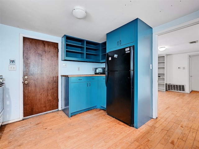 kitchen with light hardwood / wood-style floors, blue cabinets, and black appliances