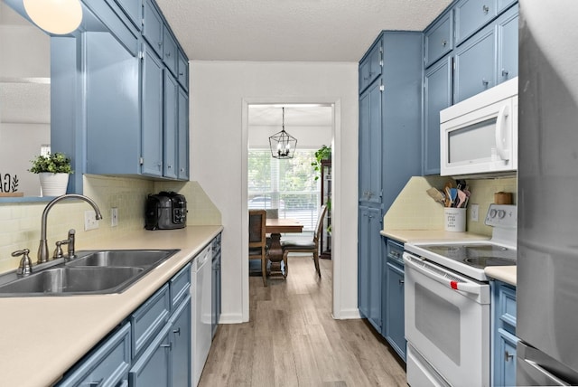 kitchen with blue cabinetry, sink, light hardwood / wood-style floors, and appliances with stainless steel finishes