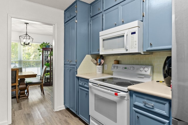 kitchen featuring white appliances, an inviting chandelier, hanging light fixtures, light hardwood / wood-style flooring, and blue cabinetry