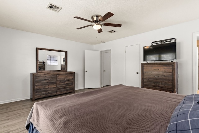 bedroom with wood-type flooring, a textured ceiling, and ceiling fan