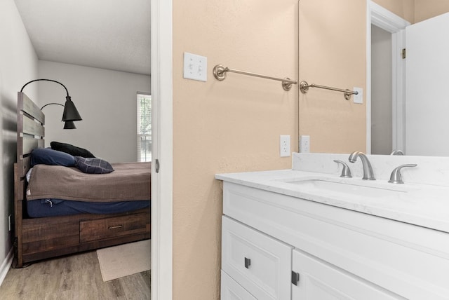 bathroom featuring hardwood / wood-style flooring, vanity, and a textured ceiling