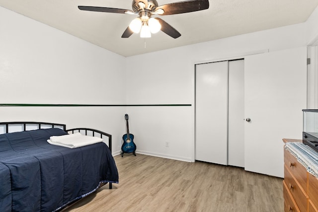 bedroom featuring ceiling fan, a closet, and light hardwood / wood-style flooring