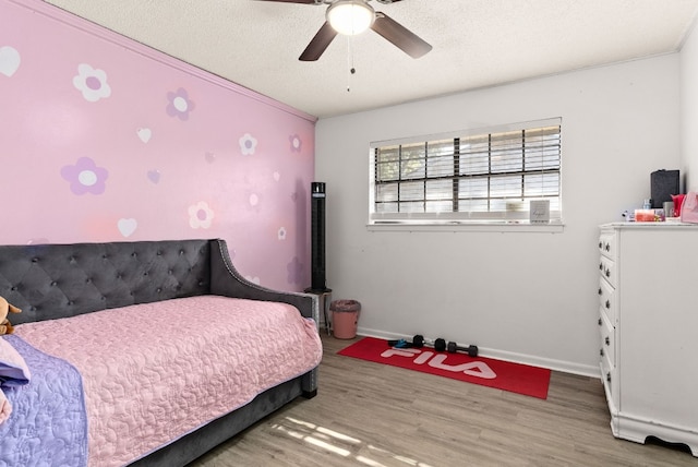 bedroom with ceiling fan, crown molding, a textured ceiling, and hardwood / wood-style flooring