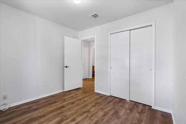 unfurnished bedroom featuring dark hardwood / wood-style floors and a closet