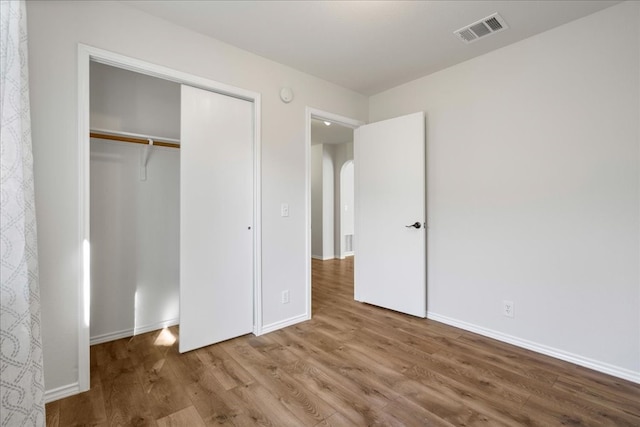 unfurnished bedroom featuring a closet and hardwood / wood-style flooring