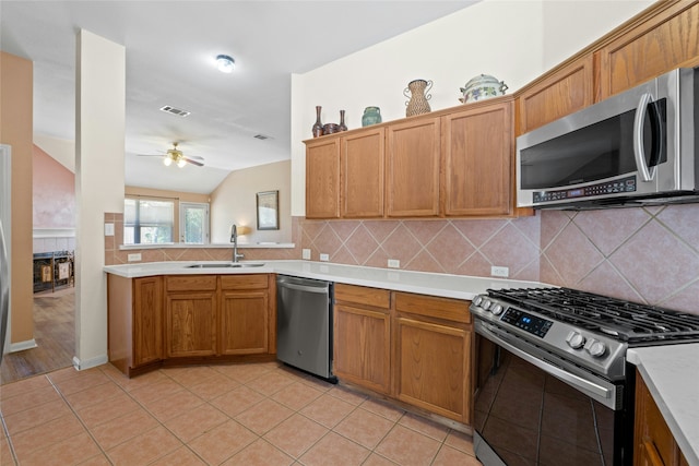 kitchen featuring ceiling fan, lofted ceiling, sink, stainless steel appliances, and light tile patterned floors