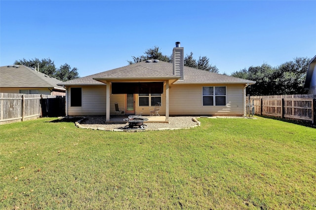 back of property featuring a lawn and a fire pit