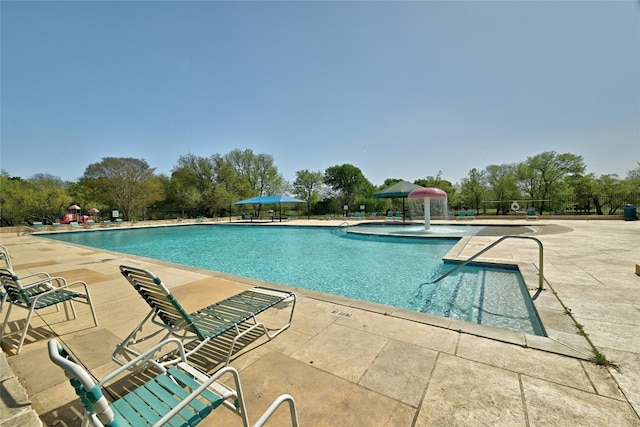 view of swimming pool featuring pool water feature and a patio