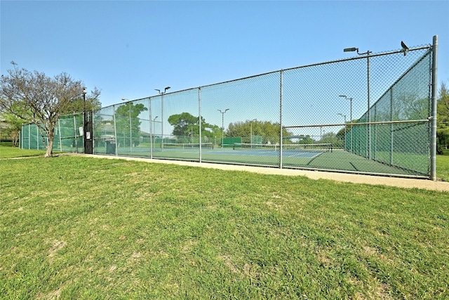 view of sport court with a lawn