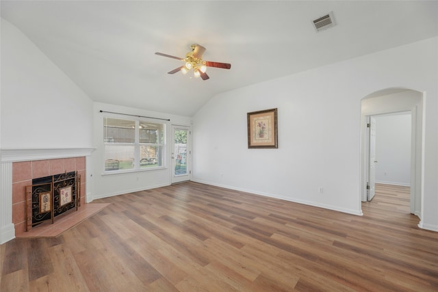 unfurnished living room with ceiling fan, light hardwood / wood-style flooring, a tile fireplace, and lofted ceiling